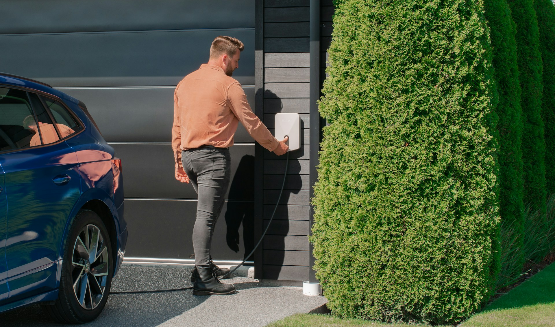 Man laadt zijn elektrische wagen thuis op